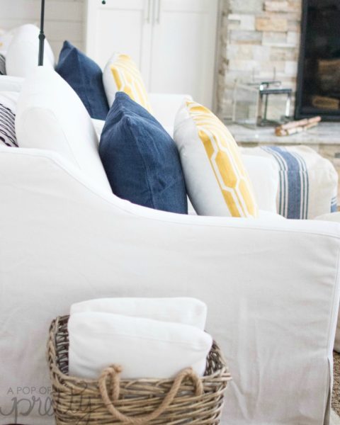 Coastal style lake house living room with blue striped poufs